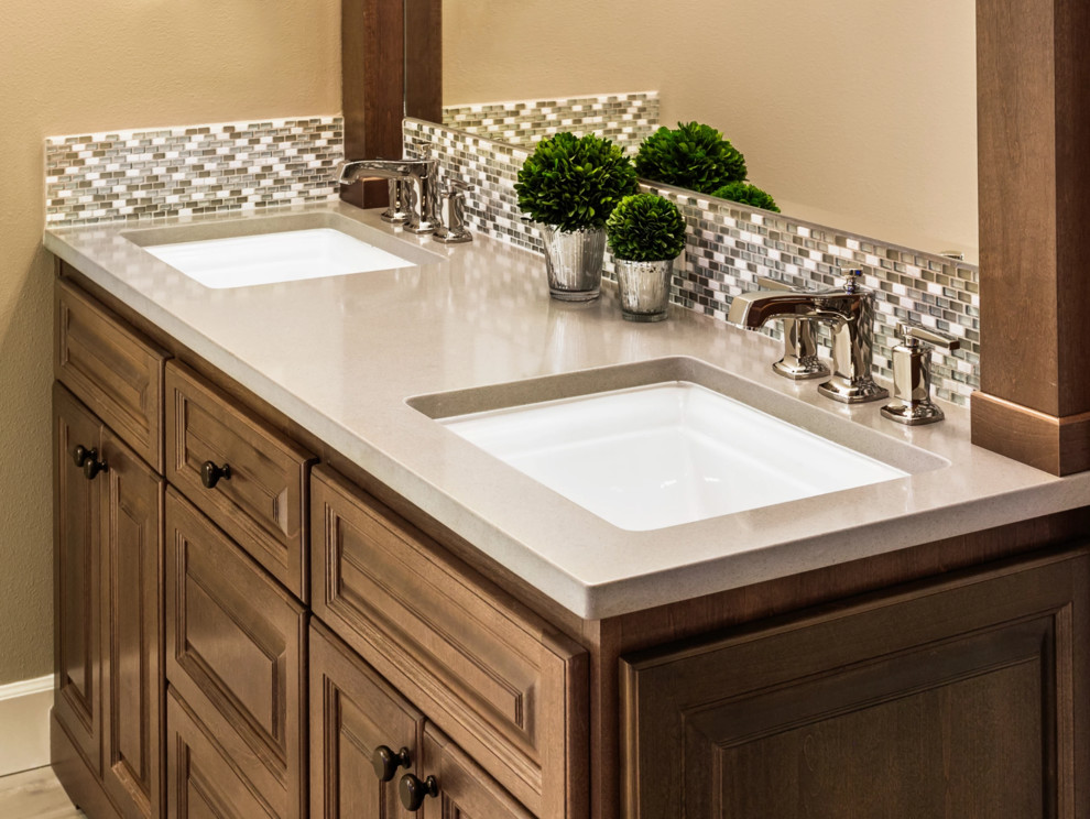 Freestanding bathtub - mid-sized transitional master white tile and marble tile porcelain tile and brown floor freestanding bathtub idea with raised-panel cabinets, medium tone wood cabinets, brown walls, an undermount sink, solid surface countertops, a hinged shower door and gray countertops