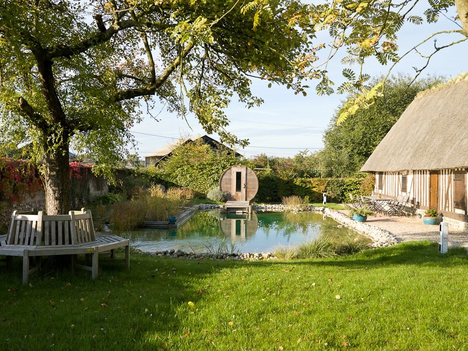 Photo of a mid-sized country custom-shaped natural pool in Le Havre with a water feature.