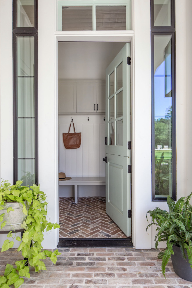 Photo of a mid-sized country mudroom in Houston with white walls, brick floors, a dutch front door, a blue front door, brown floor and planked wall panelling.