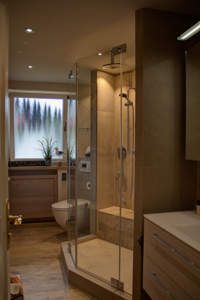 This is an example of a small traditional 3/4 bathroom in Munich with flat-panel cabinets, beige cabinets, a curbless shower, a two-piece toilet, beige tile, wood-look tile, beige walls, wood-look tile, an integrated sink, glass benchtops, brown floor, a hinged shower door, white benchtops, a shower seat, a single vanity, a floating vanity, recessed and wallpaper.