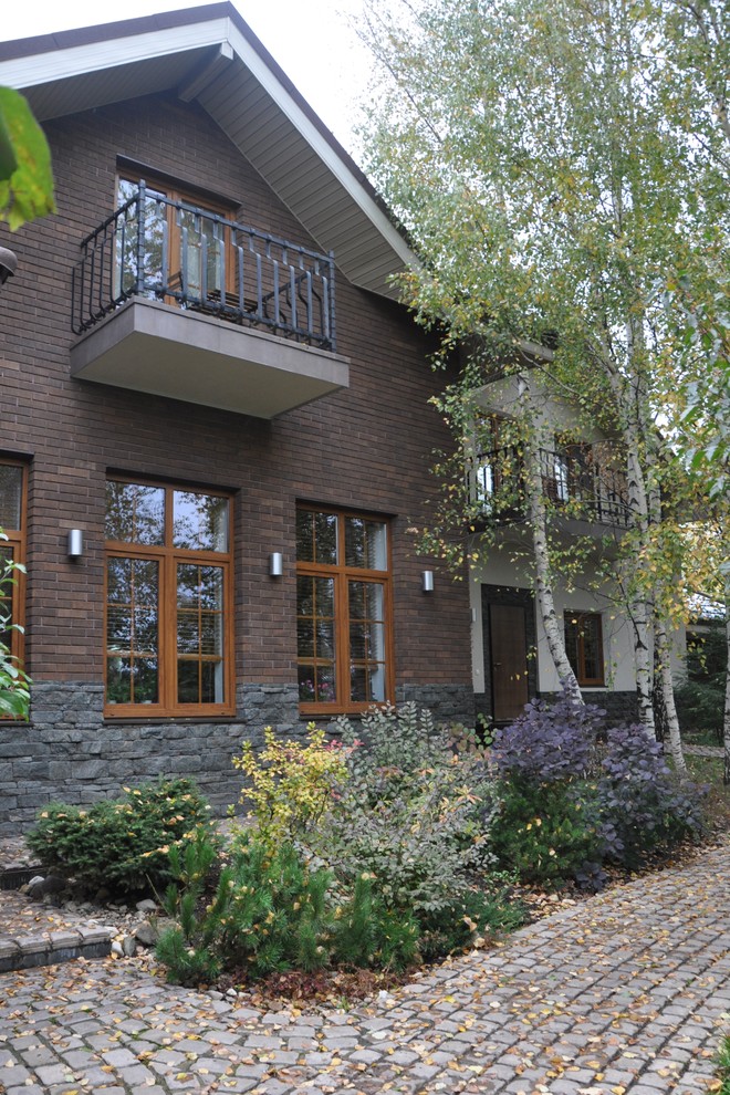 Inspiration for a large contemporary two-storey brick brown exterior in Moscow with a gable roof.