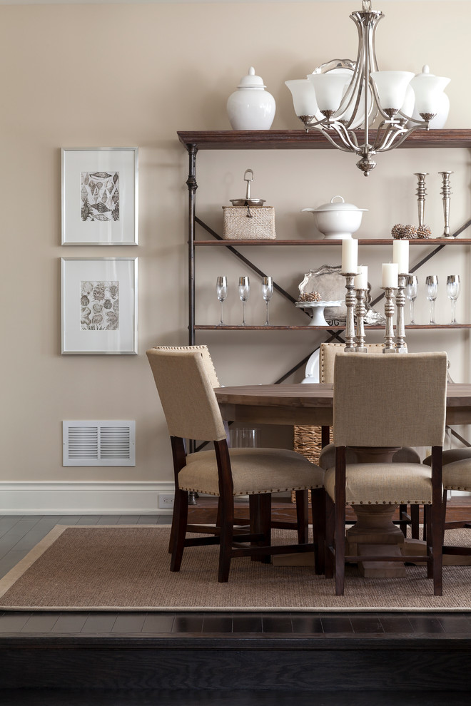 This is an example of a traditional dining room in Toronto with beige walls and dark hardwood floors.