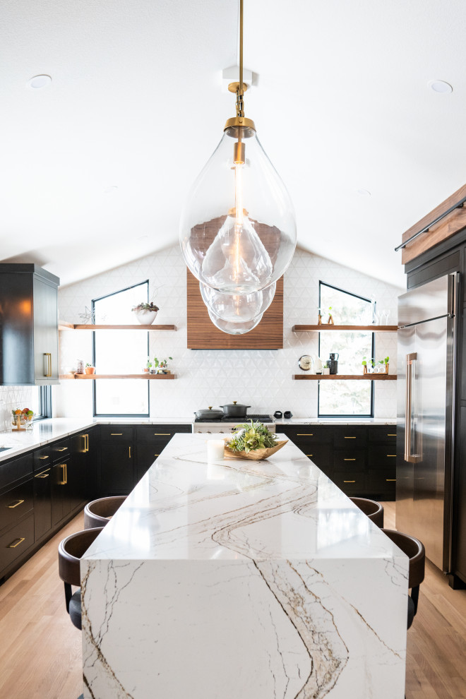 Photo of a midcentury kitchen in Other with an undermount sink, flat-panel cabinets, black cabinets, quartz benchtops, white splashback, ceramic splashback, stainless steel appliances, light hardwood floors, with island, multi-coloured benchtop and vaulted.