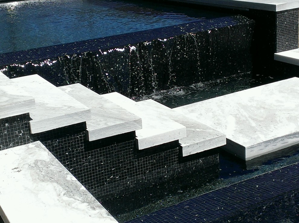Design ideas for a small contemporary backyard custom-shaped infinity pool in Boston with a water feature and decking.