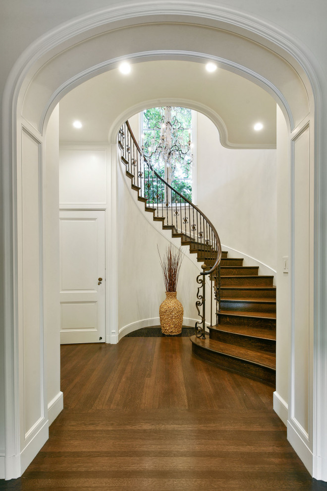 Design ideas for a large mediterranean wood curved staircase in San Francisco with wood risers, metal railing and decorative wall panelling.