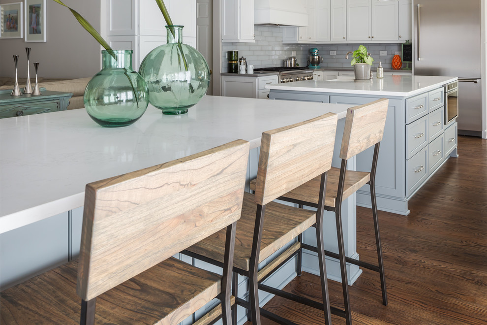 Huge transitional galley medium tone wood floor home design photo in Raleigh with a farmhouse sink, flat-panel cabinets, white cabinets, quartz countertops, gray backsplash, ceramic backsplash, stainless steel appliances and two islands