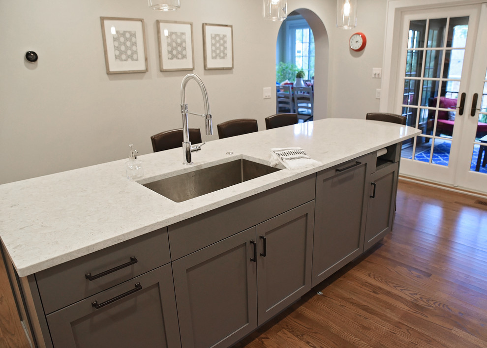 Example of a mid-sized transitional enclosed kitchen design with flat-panel cabinets, gray cabinets, quartz countertops, an island and gray countertops