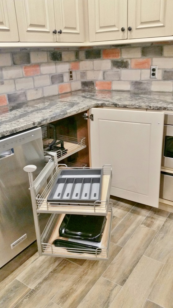 Kitchen - large light wood floor kitchen idea with raised-panel cabinets, white cabinets, quartzite countertops, multicolored backsplash, subway tile backsplash, stainless steel appliances and an island