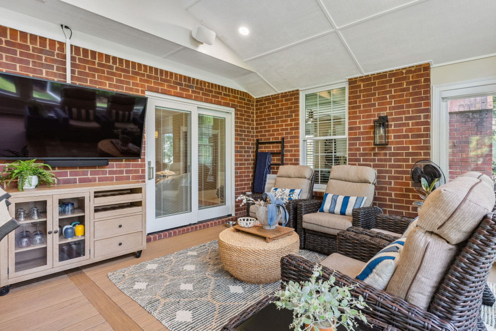 Design ideas for a large traditional backyard screened-in verandah in Columbus with decking and a roof extension.