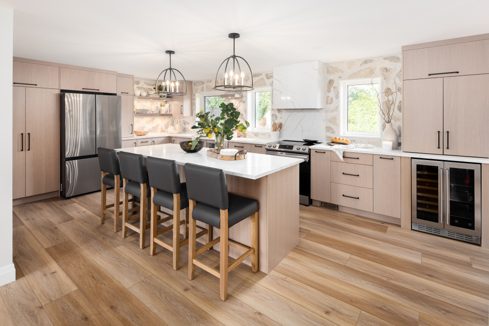 Transitional l-shaped vinyl floor eat-in kitchen photo with an undermount sink, flat-panel cabinets, light wood cabinets, quartz countertops, beige backsplash, quartz backsplash, stainless steel appliances, an island and white countertops