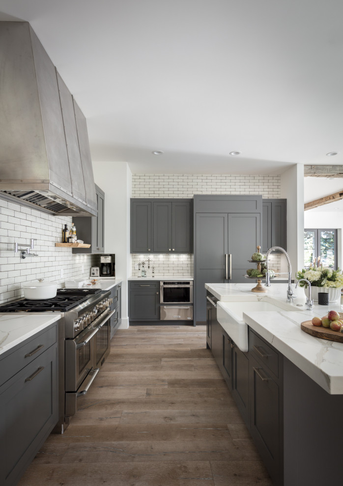 Exempel på ett stort lantligt vit vitt kök, med en rustik diskho, skåp i shakerstil, grå skåp, bänkskiva i kvarts, vitt stänkskydd, stänkskydd i keramik, rostfria vitvaror, mellanmörkt trägolv, en köksö och grått golv