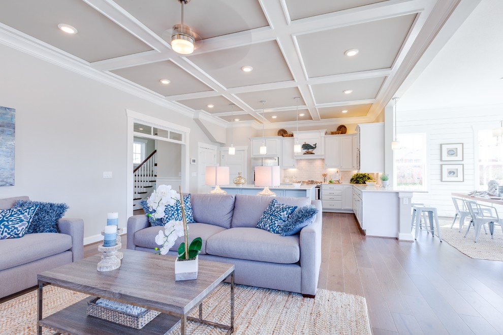 Large beach style medium tone wood floor family room photo in Other with gray walls, a standard fireplace, a tile fireplace and a media wall