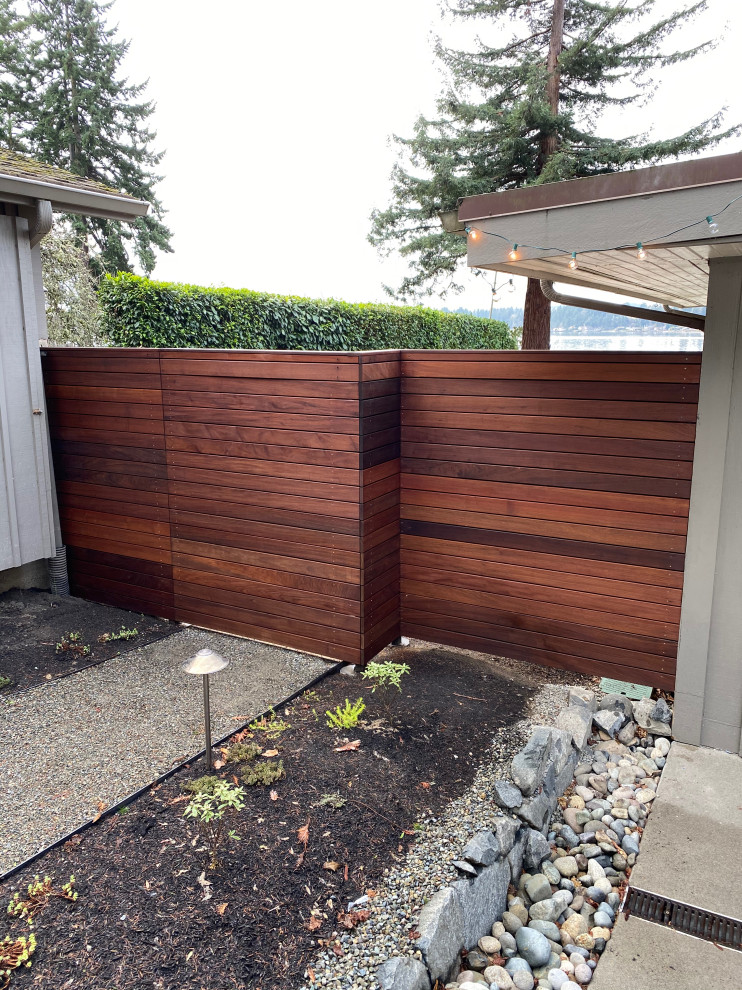 Modern side yard garden in Seattle with with a gate and river rock.