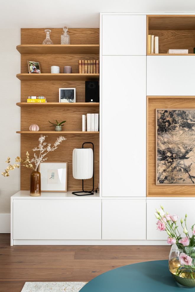 Immagine di un grande soggiorno design aperto con sala formale, pareti beige, pavimento in legno massello medio, TV a parete, pavimento marrone e pannellatura