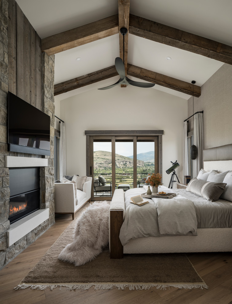 Bedroom - rustic medium tone wood floor, brown floor, exposed beam and vaulted ceiling bedroom idea in Salt Lake City with gray walls and a ribbon fireplace