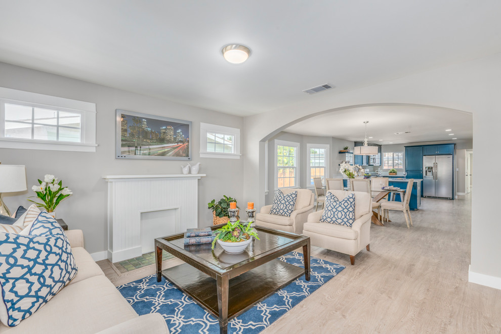 Example of a beach style formal and open concept light wood floor living room design in Los Angeles with gray walls