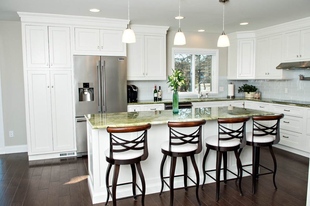 Inspiration for a large traditional l-shaped eat-in kitchen in Detroit with an undermount sink, beaded inset cabinets, white cabinets, granite benchtops, green splashback, glass tile splashback, stainless steel appliances, medium hardwood floors, with island, brown floor and green benchtop.