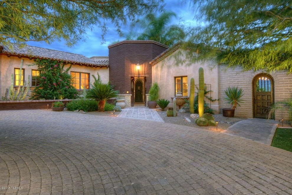 Photo of a mid-sized country one-storey adobe beige exterior in Phoenix with a gable roof.