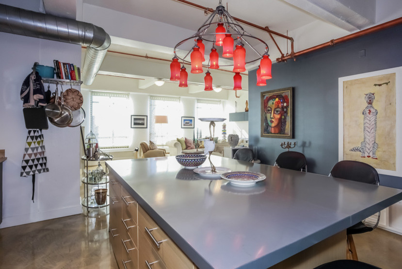 Eclectic kitchen in Los Angeles with an undermount sink, flat-panel cabinets, medium wood cabinets, zinc benchtops, green splashback, ceramic splashback, stainless steel appliances, concrete floors and with island.