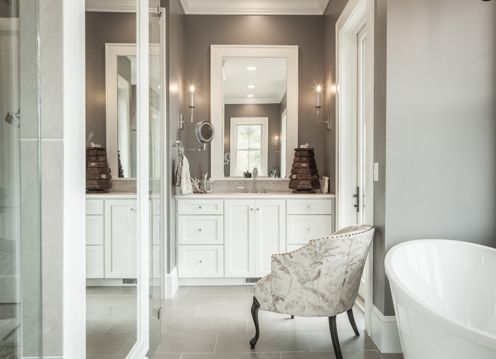 Large country master bathroom in Other with shaker cabinets, white cabinets, porcelain floors, grey floor, a freestanding tub and an undermount sink.