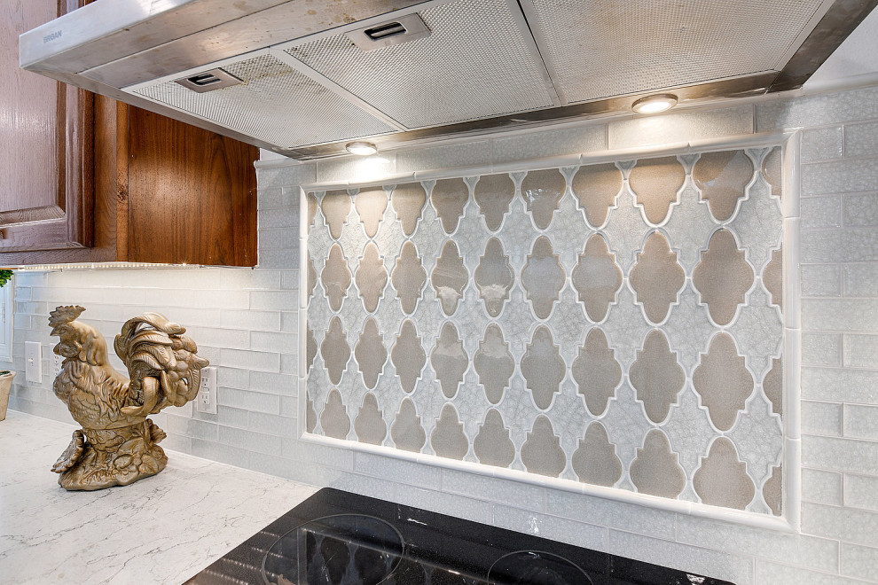 Mid-sized transitional ceramic tile and white floor eat-in kitchen photo with an undermount sink, raised-panel cabinets, white backsplash, stainless steel appliances, an island, dark wood cabinets, quartz countertops, glass tile backsplash and white countertops