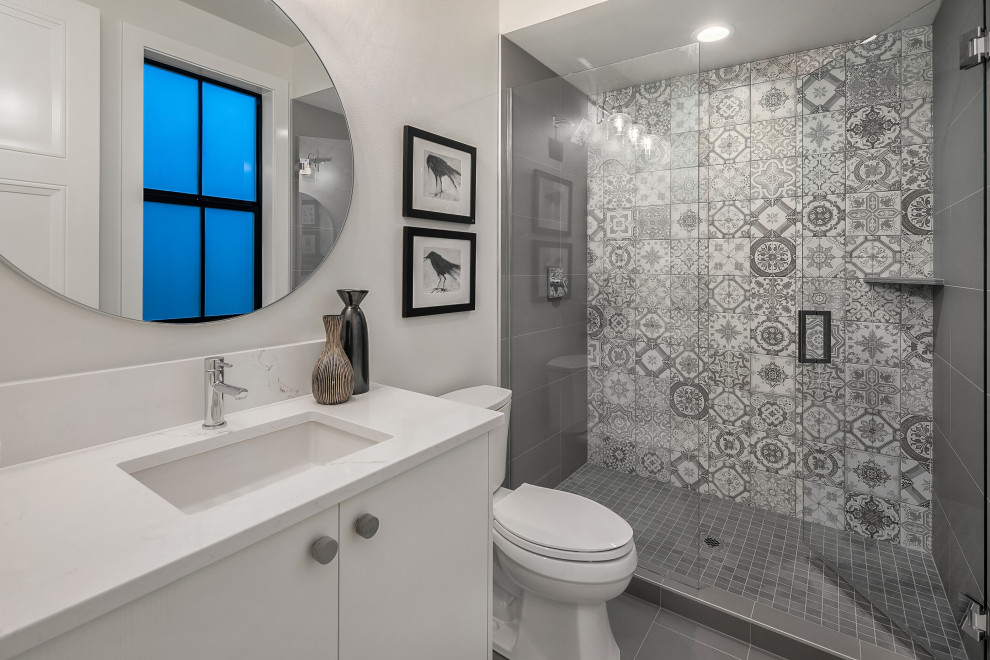 Design ideas for a mid-sized country 3/4 bathroom in Seattle with flat-panel cabinets, white cabinets, an alcove shower, a two-piece toilet, gray tile, mosaic tile, white walls, an undermount sink, grey floor, a hinged shower door and white benchtops.