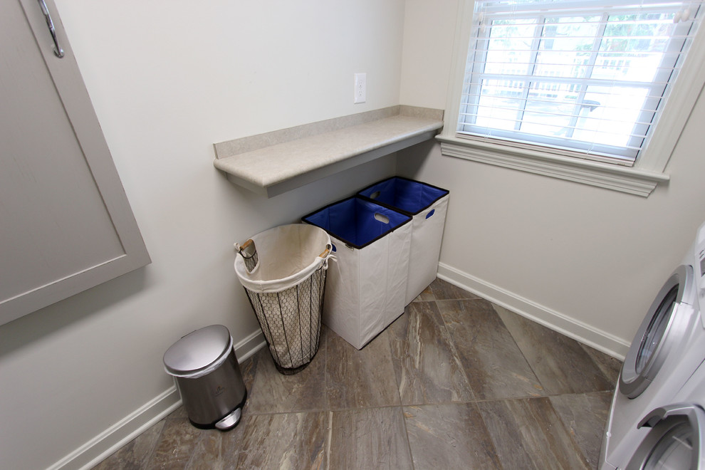 Small transitional galley dedicated laundry room in Cleveland with an undermount sink, shaker cabinets, grey cabinets, laminate benchtops, grey walls, porcelain floors and a side-by-side washer and dryer.