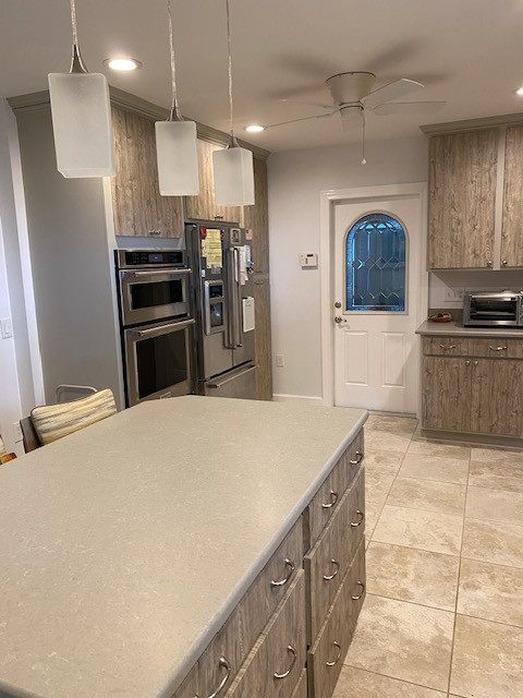 Inspiration for a large l-shaped eat-in kitchen remodel with an undermount sink, flat-panel cabinets, medium tone wood cabinets, stainless steel appliances and an island