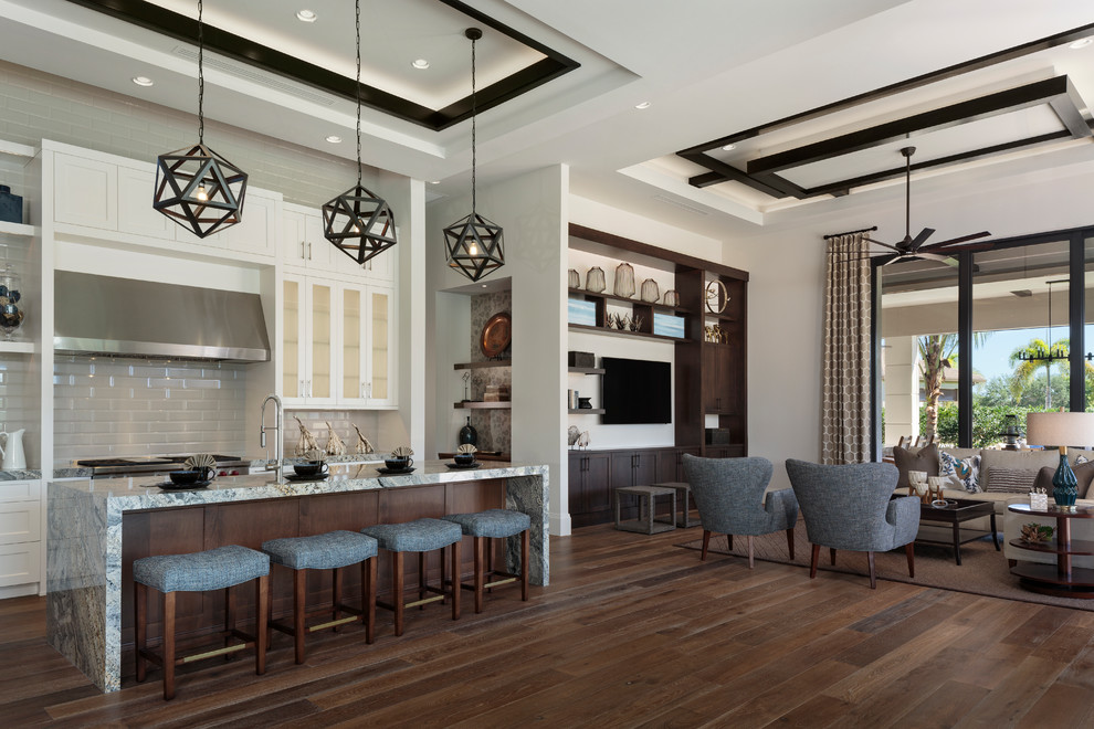 Example of a mid-sized transitional l-shaped dark wood floor and brown floor open concept kitchen design in Miami with shaker cabinets, white cabinets, granite countertops, white backsplash, subway tile backsplash and an island
