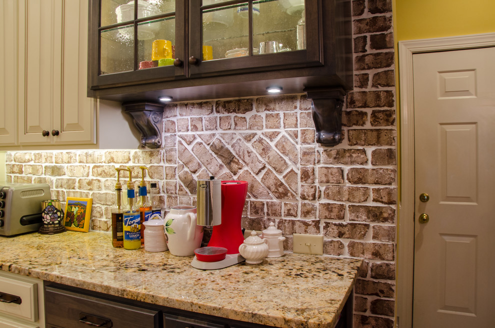 Example of a large transitional u-shaped medium tone wood floor eat-in kitchen design in Raleigh with a farmhouse sink, raised-panel cabinets, beige cabinets, granite countertops, multicolored backsplash, terra-cotta backsplash, stainless steel appliances and a peninsula