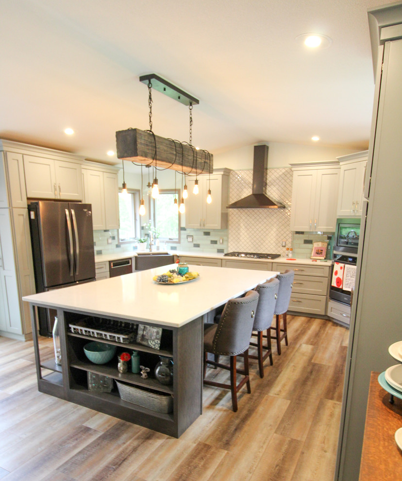 Kitchen - kitchen idea with a farmhouse sink, shaker cabinets, quartz countertops, stainless steel appliances, an island and white countertops