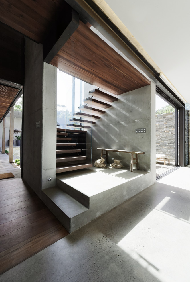 Photo of a mid-sized contemporary wood floating staircase in Central Coast with open risers and glass railing.
