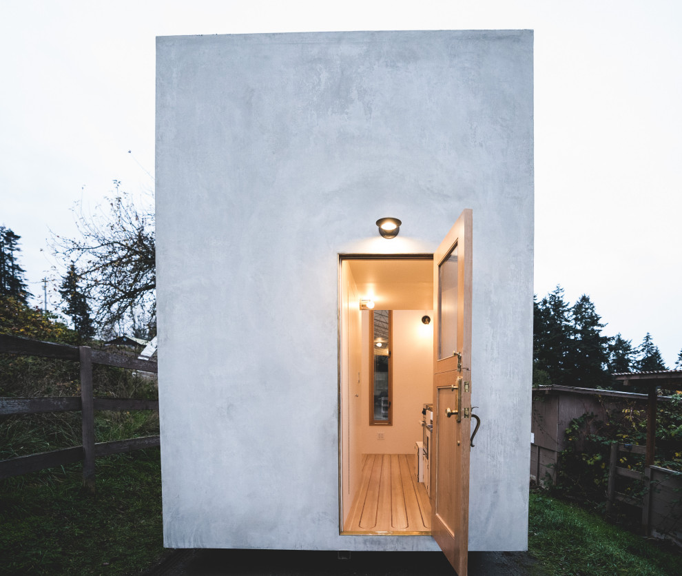 Идея дизайна: маленький, одноэтажный, серый мини дом в современном стиле с облицовкой из бетона, плоской крышей и белой крышей для на участке и в саду