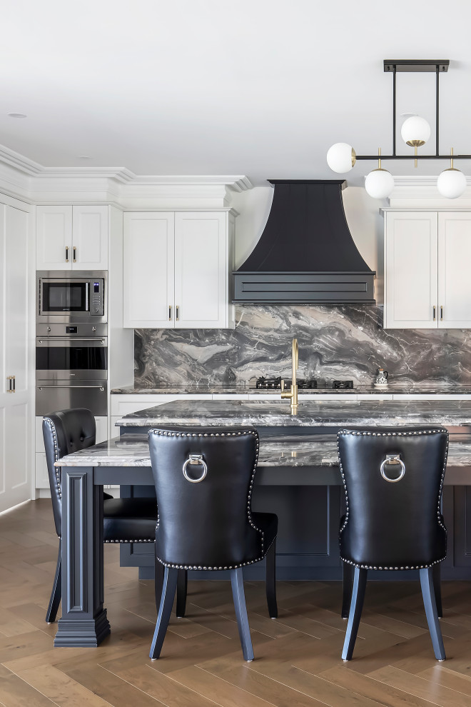 Photo of an expansive traditional l-shaped eat-in kitchen in Sydney with an undermount sink, shaker cabinets, blue cabinets, granite benchtops, multi-coloured splashback, granite splashback, stainless steel appliances, medium hardwood floors, with island, brown floor, multi-coloured benchtop and recessed.