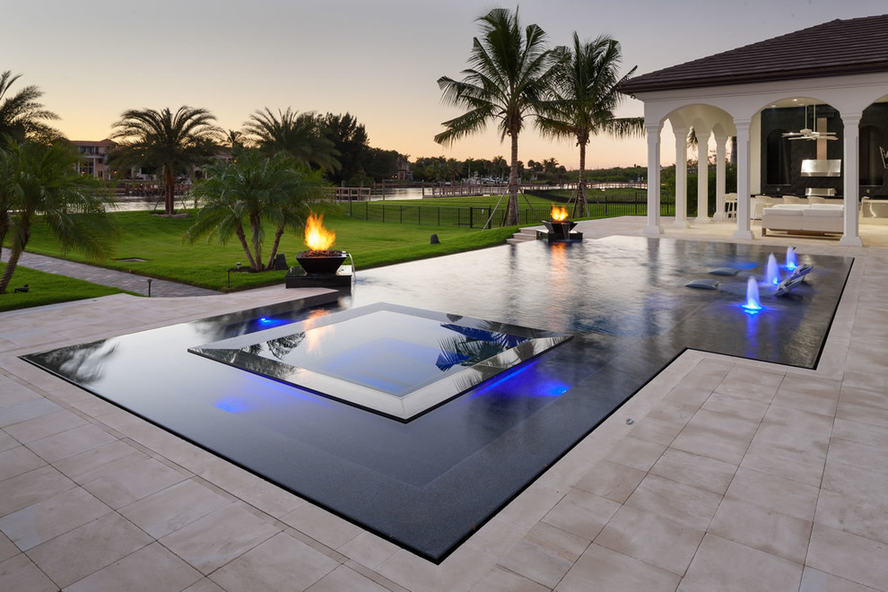 Design ideas for a large contemporary backyard custom-shaped infinity pool in Miami with a hot tub and tile.