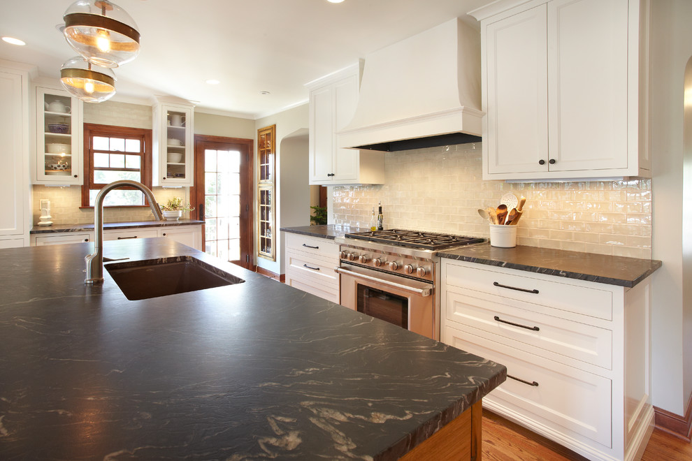 Inspiration for a mid-sized transitional u-shaped eat-in kitchen in Minneapolis with an undermount sink, flat-panel cabinets, white cabinets, granite benchtops, green splashback, ceramic splashback, stainless steel appliances, medium hardwood floors and with island.