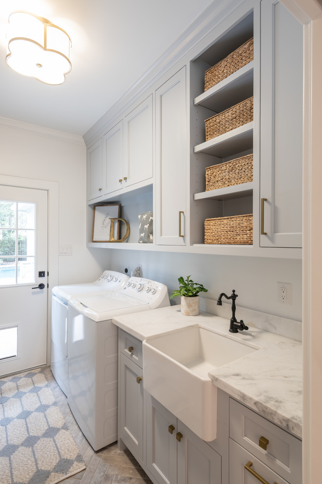 Country single-wall dedicated laundry room in Houston with a farmhouse sink, recessed-panel cabinets, grey cabinets, white walls, a side-by-side washer and dryer, grey floor and white benchtop.
