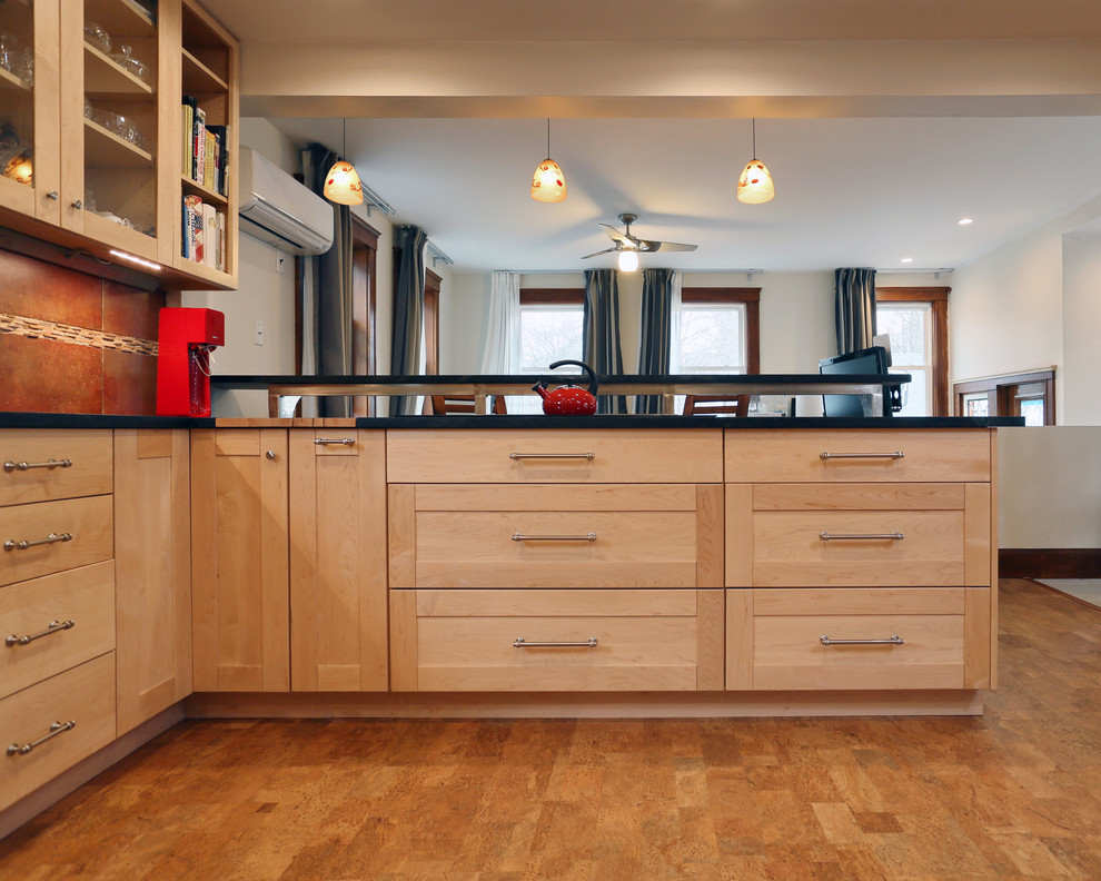 Large transitional u-shaped eat-in kitchen in Boston with a farmhouse sink, shaker cabinets, light wood cabinets, soapstone benchtops, multi-coloured splashback, stone tile splashback, stainless steel appliances, cork floors and a peninsula.