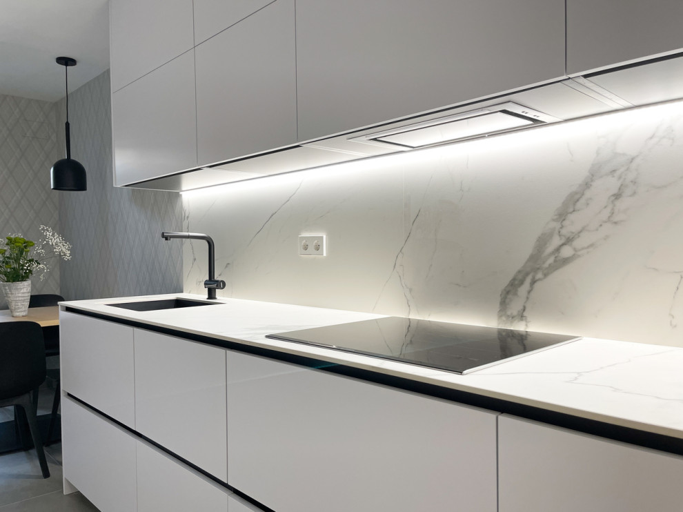 Esempio di una cucina moderna chiusa e di medie dimensioni con lavello sottopiano, top in marmo, paraspruzzi bianco, paraspruzzi in marmo, elettrodomestici in acciaio inossidabile, nessuna isola e top bianco