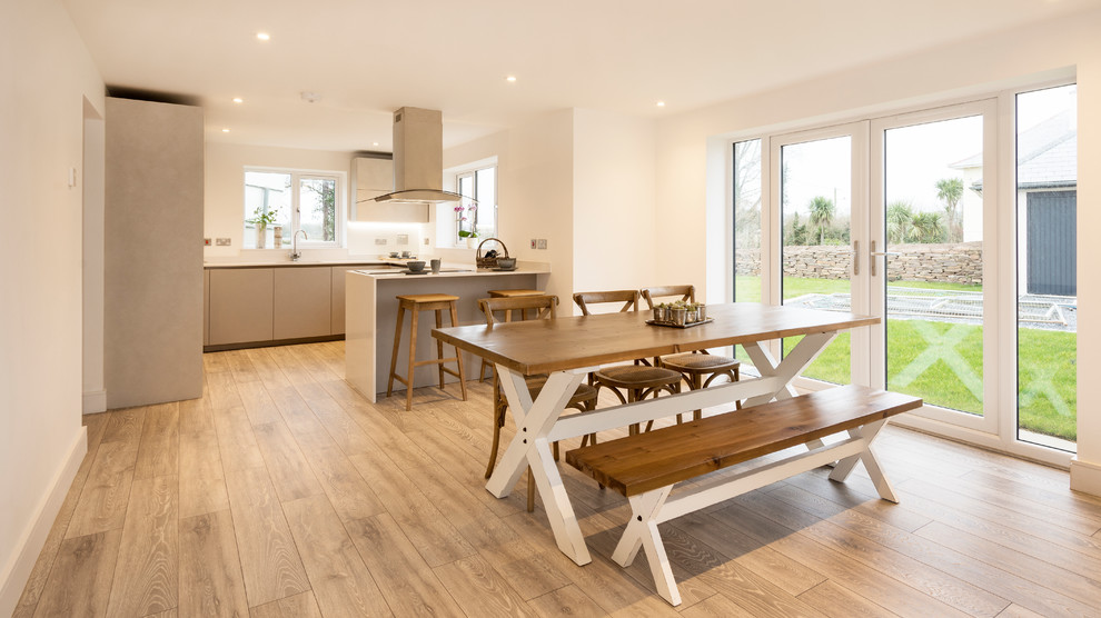 Mid-sized modern eat-in kitchen in Devon with a single-bowl sink, glass-front cabinets, blue cabinets, red splashback, stainless steel appliances, laminate floors, grey floor and white benchtop.
