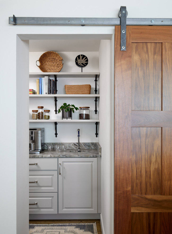 This is an example of a transitional kitchen pantry in Boston with white cabinets, quartzite benchtops, medium hardwood floors, brown floor, grey benchtop and coffered.