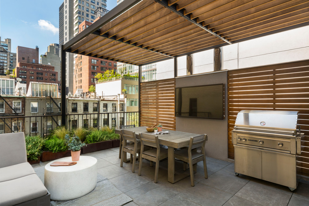 Trendy rooftop rooftop deck photo in New York with a bbq area