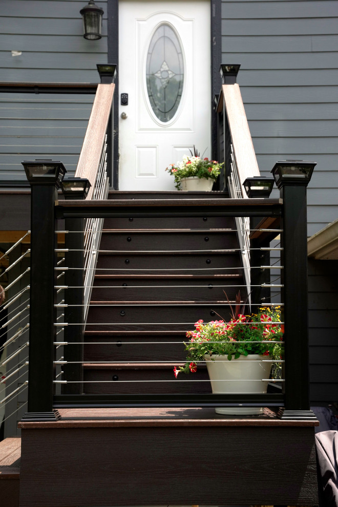 Inspiration for a mid-sized traditional backyard and first floor deck in Other with cable railing.