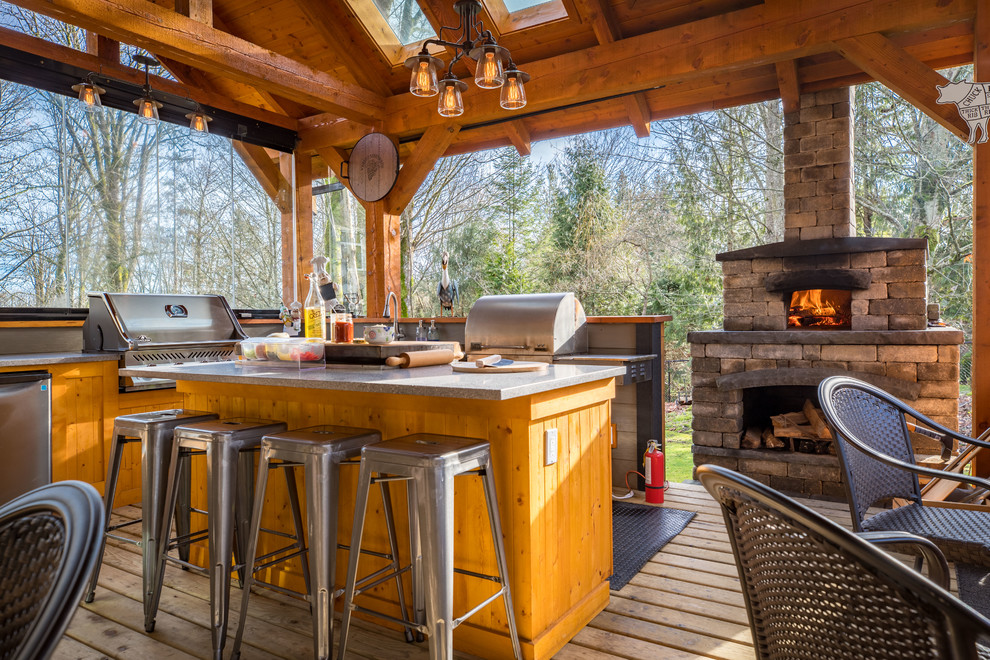 Outdoor kitchen deck - large rustic backyard outdoor kitchen deck idea in Vancouver with a roof extension