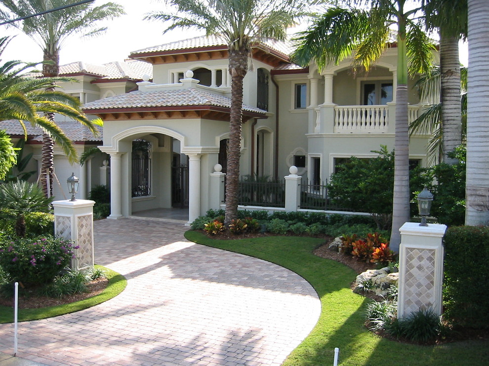 Design ideas for a large mediterranean two-storey stucco green exterior in Miami.