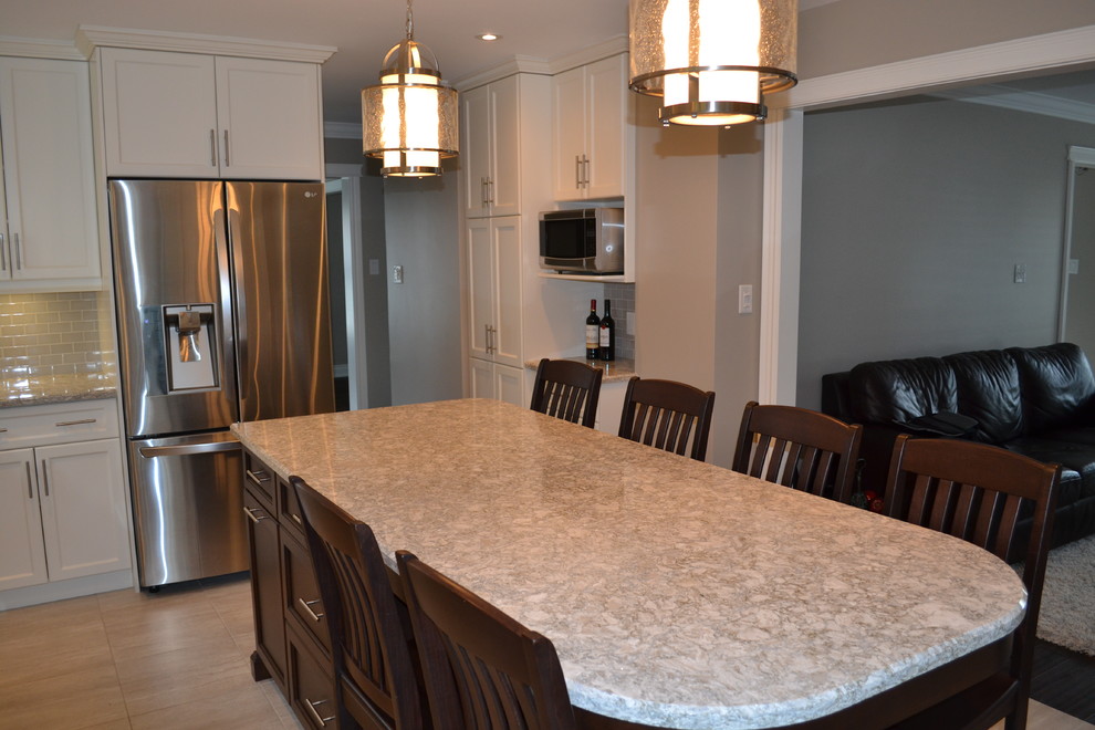 Open concept kitchen - mid-sized transitional single-wall porcelain tile open concept kitchen idea in Toronto with a double-bowl sink, recessed-panel cabinets, white cabinets, quartz countertops, gray backsplash, porcelain backsplash, stainless steel appliances and an island
