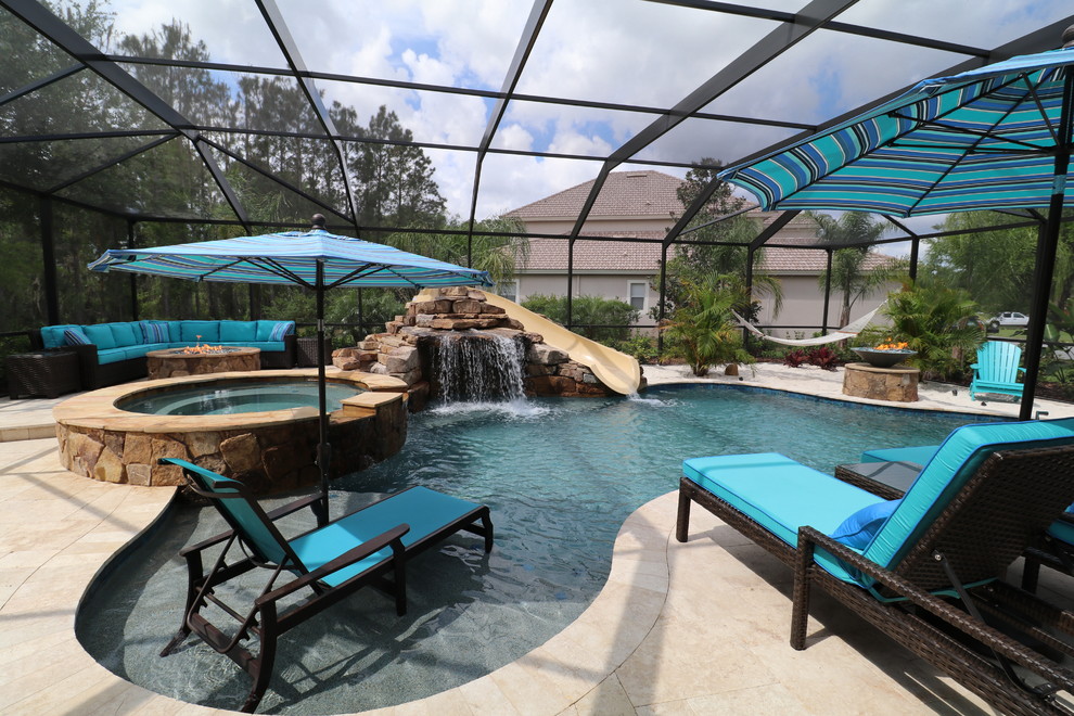 This is an example of a large transitional indoor custom-shaped pool in Tampa with a water slide and concrete pavers.