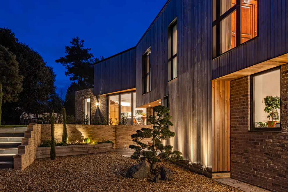 Inspiration for a large contemporary two-story wood and board and batten house exterior remodel in Hampshire