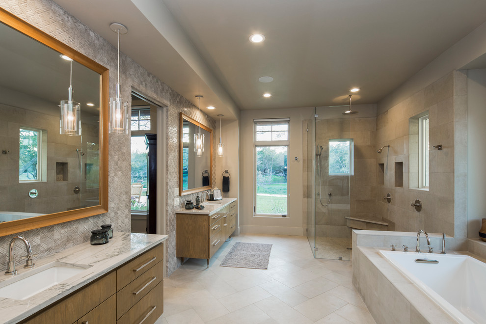 This is an example of a midcentury master bathroom in Austin with furniture-like cabinets, light wood cabinets, a drop-in tub, a curbless shower, beige tile, stone tile, beige walls, limestone floors, an undermount sink and quartzite benchtops.