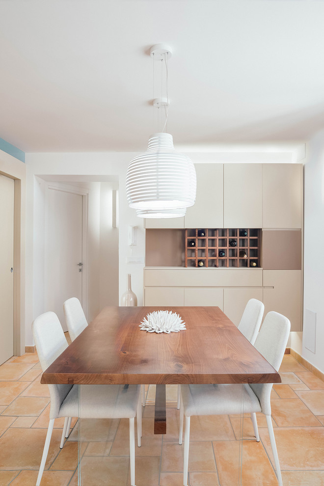This is an example of a large contemporary dining room in Naples with white walls and terra-cotta floors.